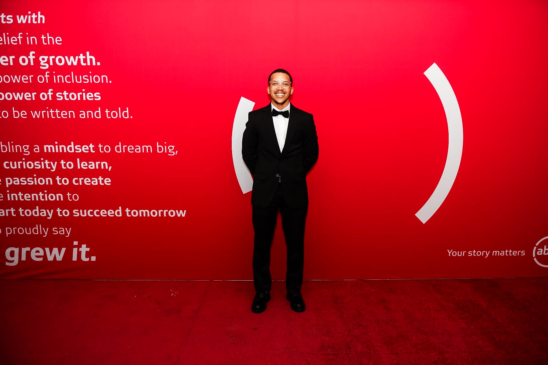 Smiling guest in a black bow-tie suit on the SANAA 2026 red carpet