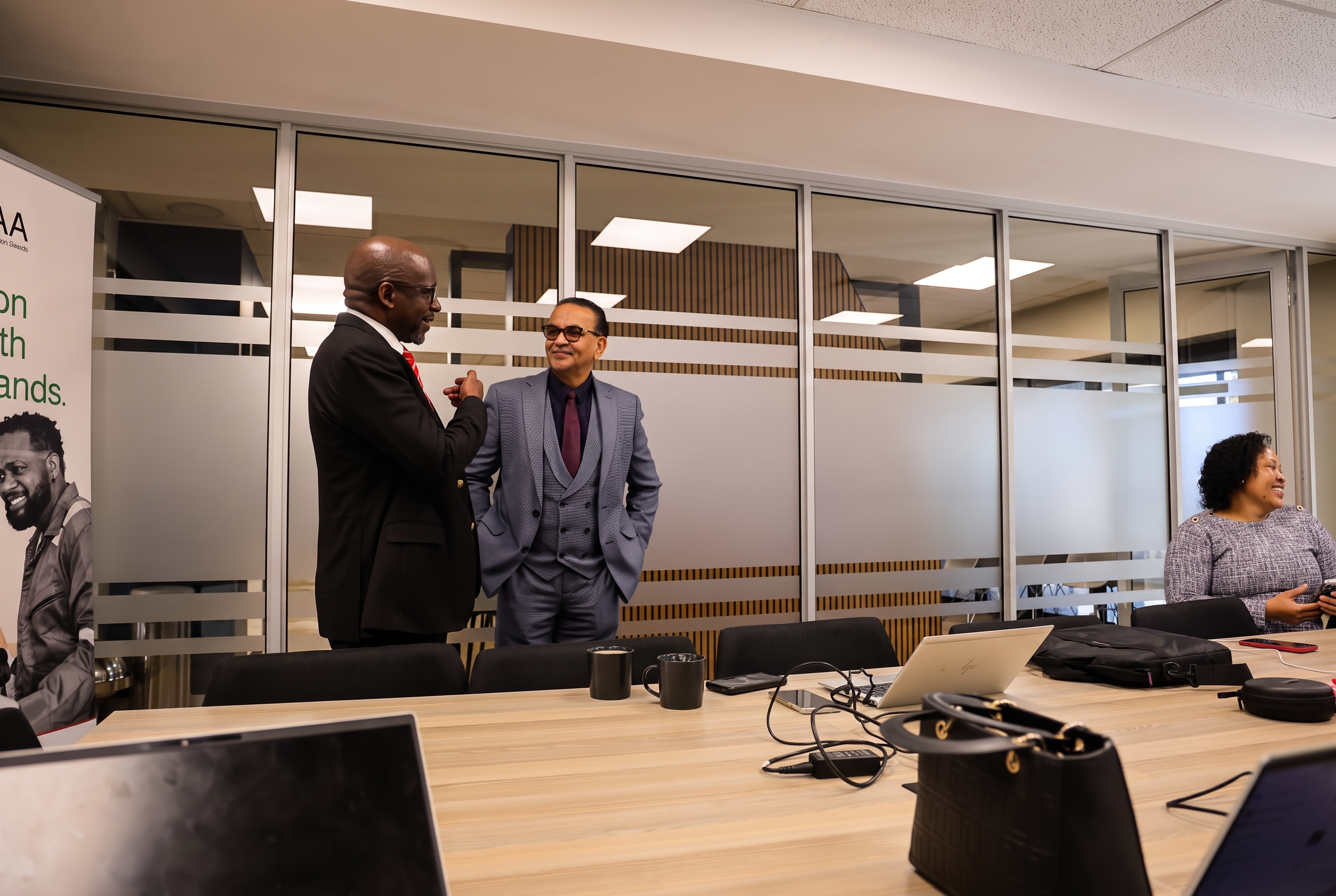 SANAA officials in conversation during a committee meeting in the boardroom