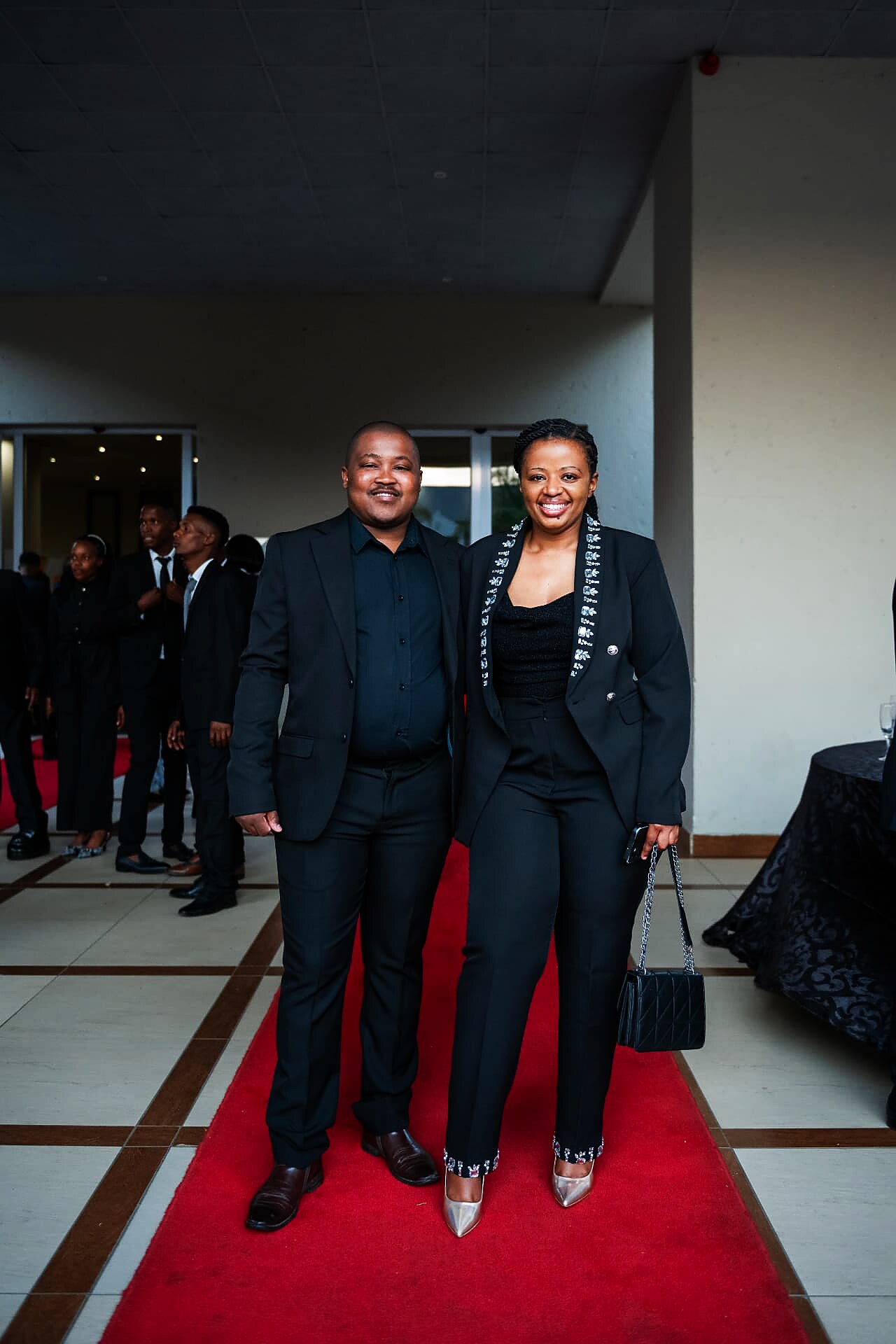 Couple in matching black formal wear arriving on the SANAA 2026 red carpet