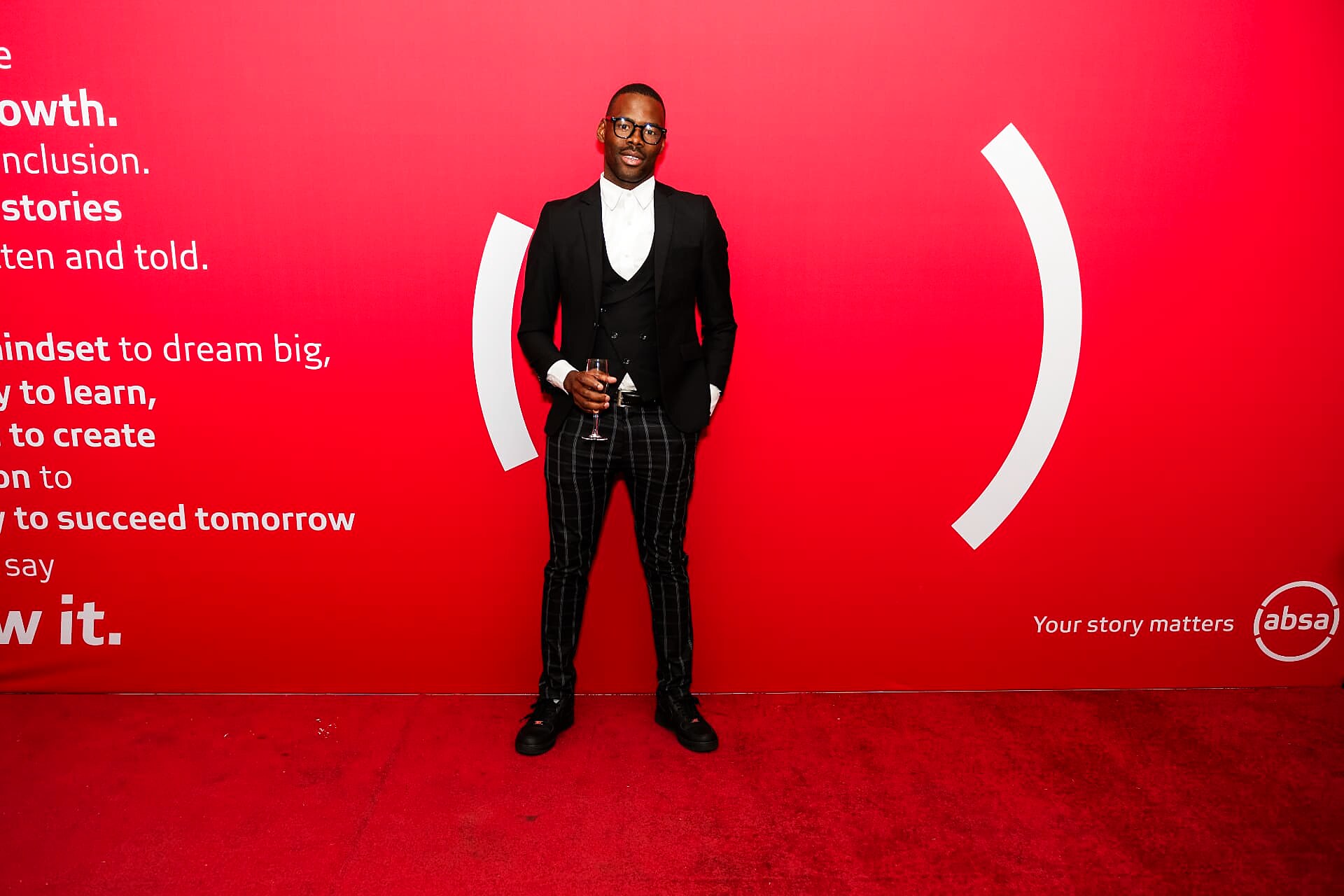 Guest in a tailored suit with checked trousers on the SANAA 2026 red carpet