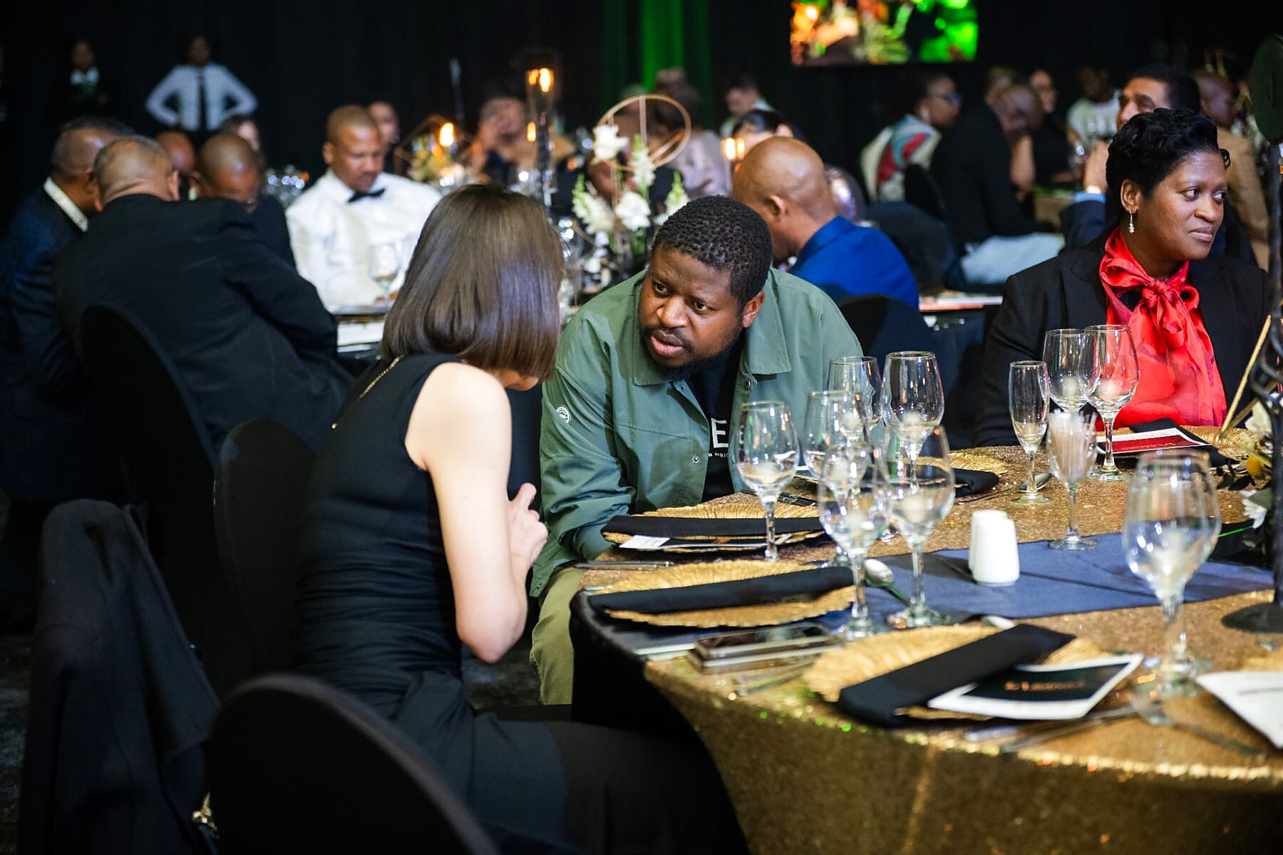 Delegates in conversation at a gold-draped gala table