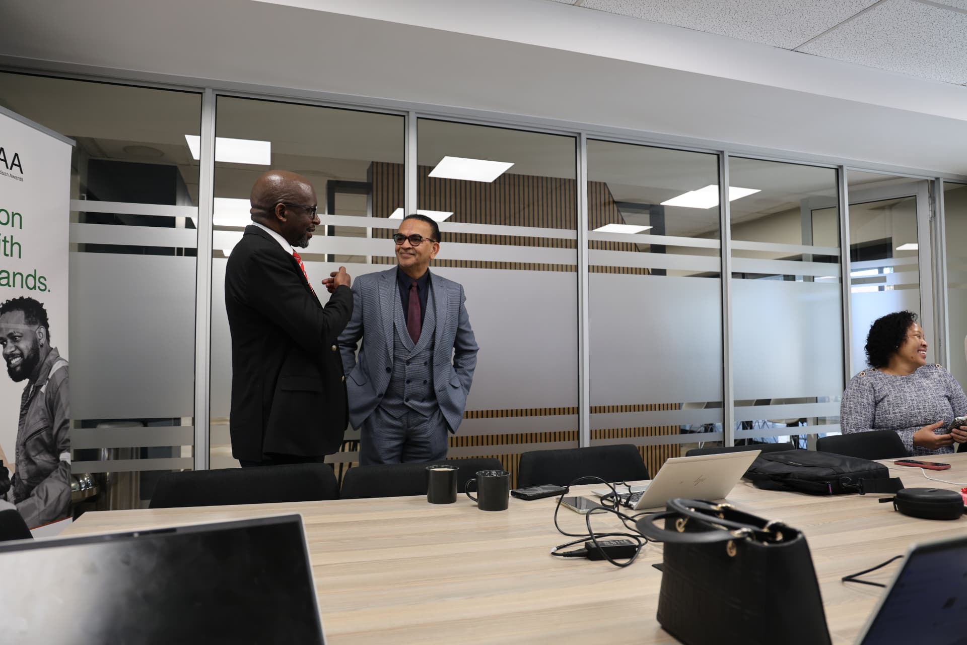 SANAA officials in conversation during a committee meeting in the boardroom