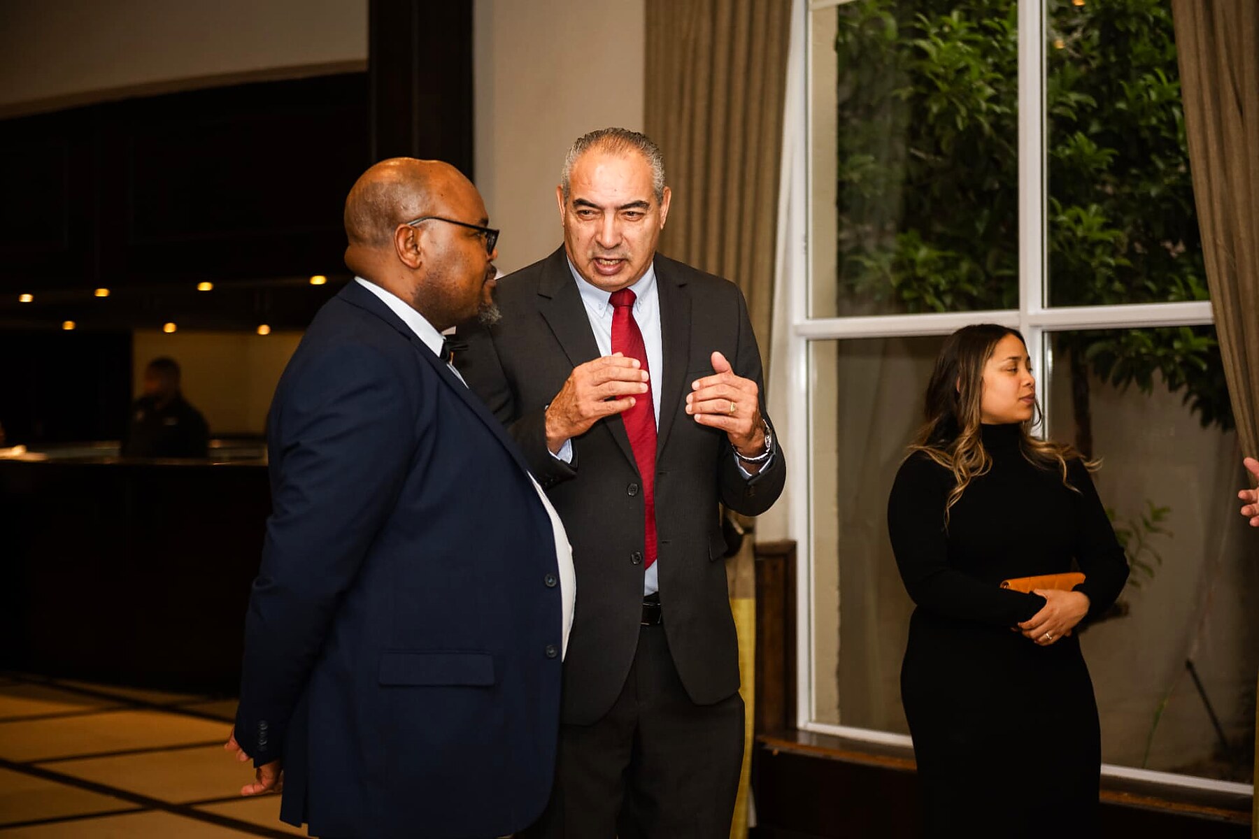 Two SANAA 2026 guests in suits in conversation during the evening reception