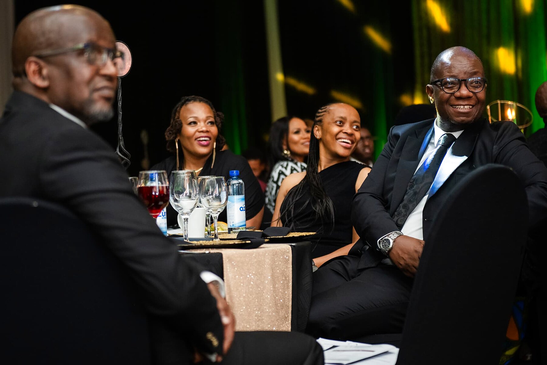 Guests laughing together while watching the awards ceremony