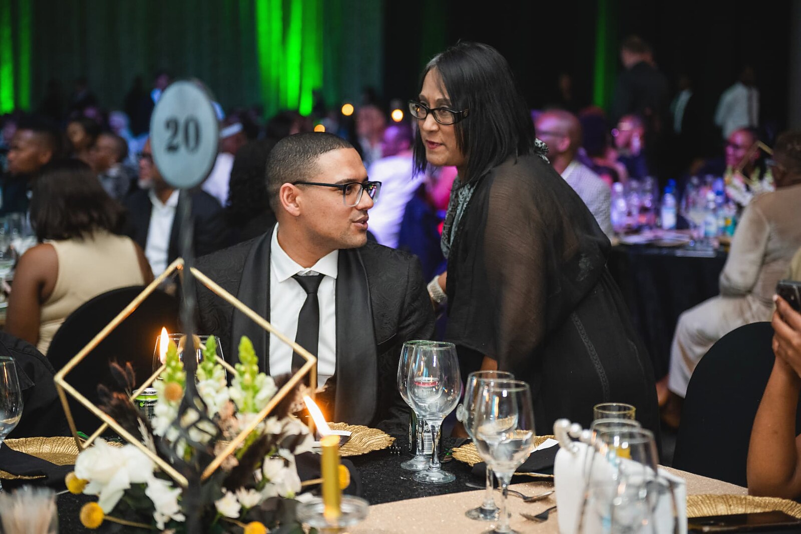 Attendees talking beside the gold and floral table setting
