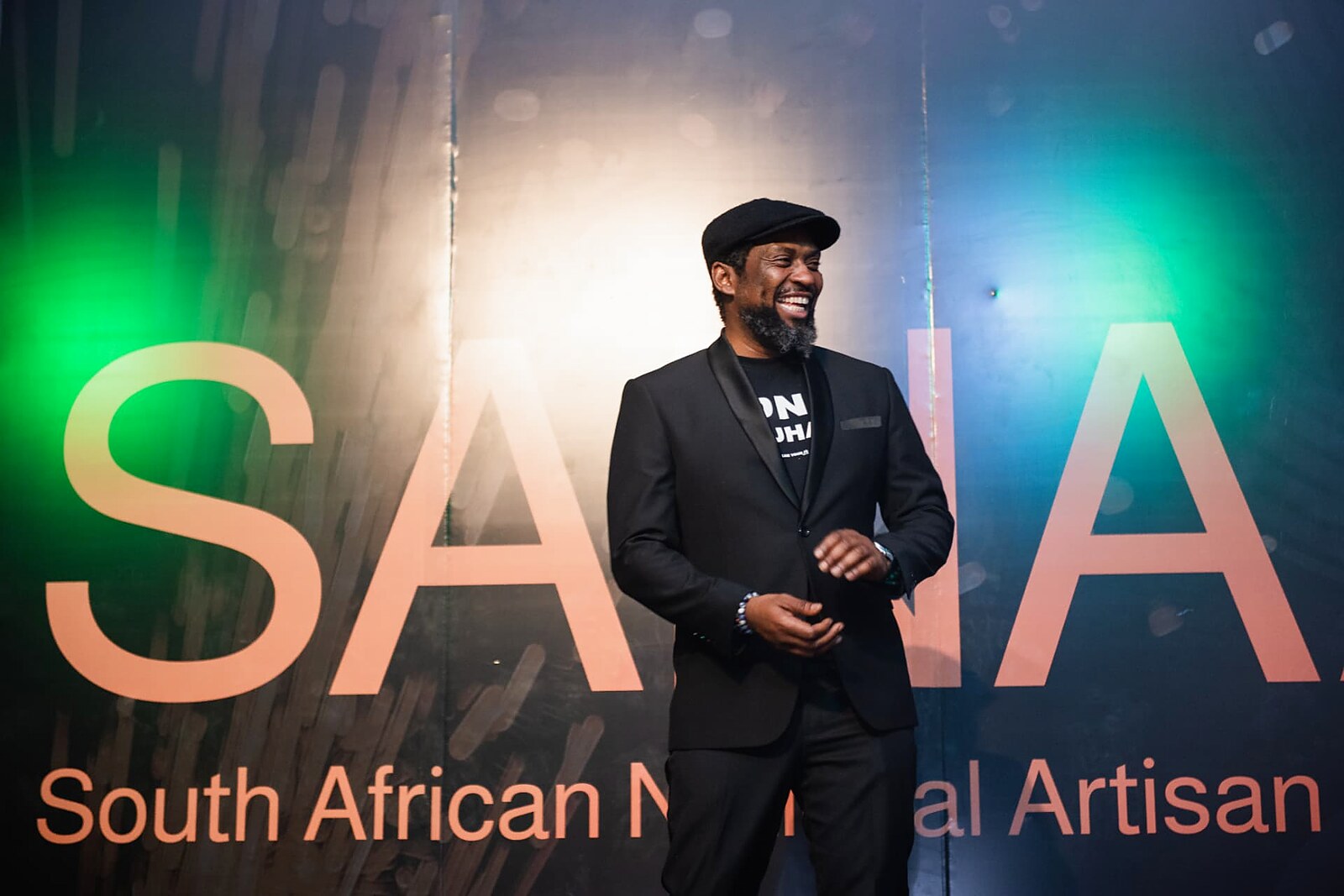Master of ceremonies smiling in front of the SANAA backdrop