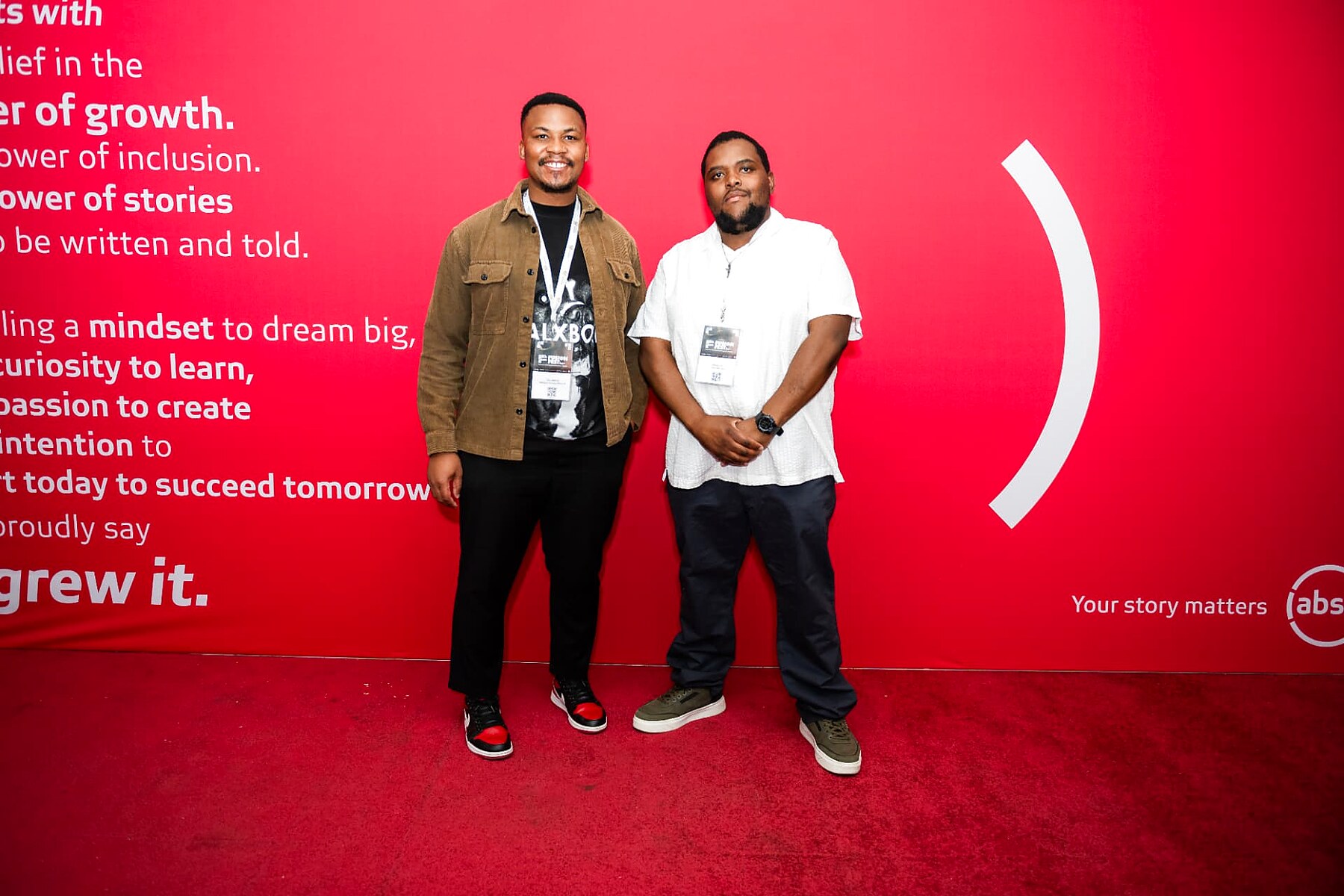 Two guests with event lanyards posing on the SANAA 2026 red carpet