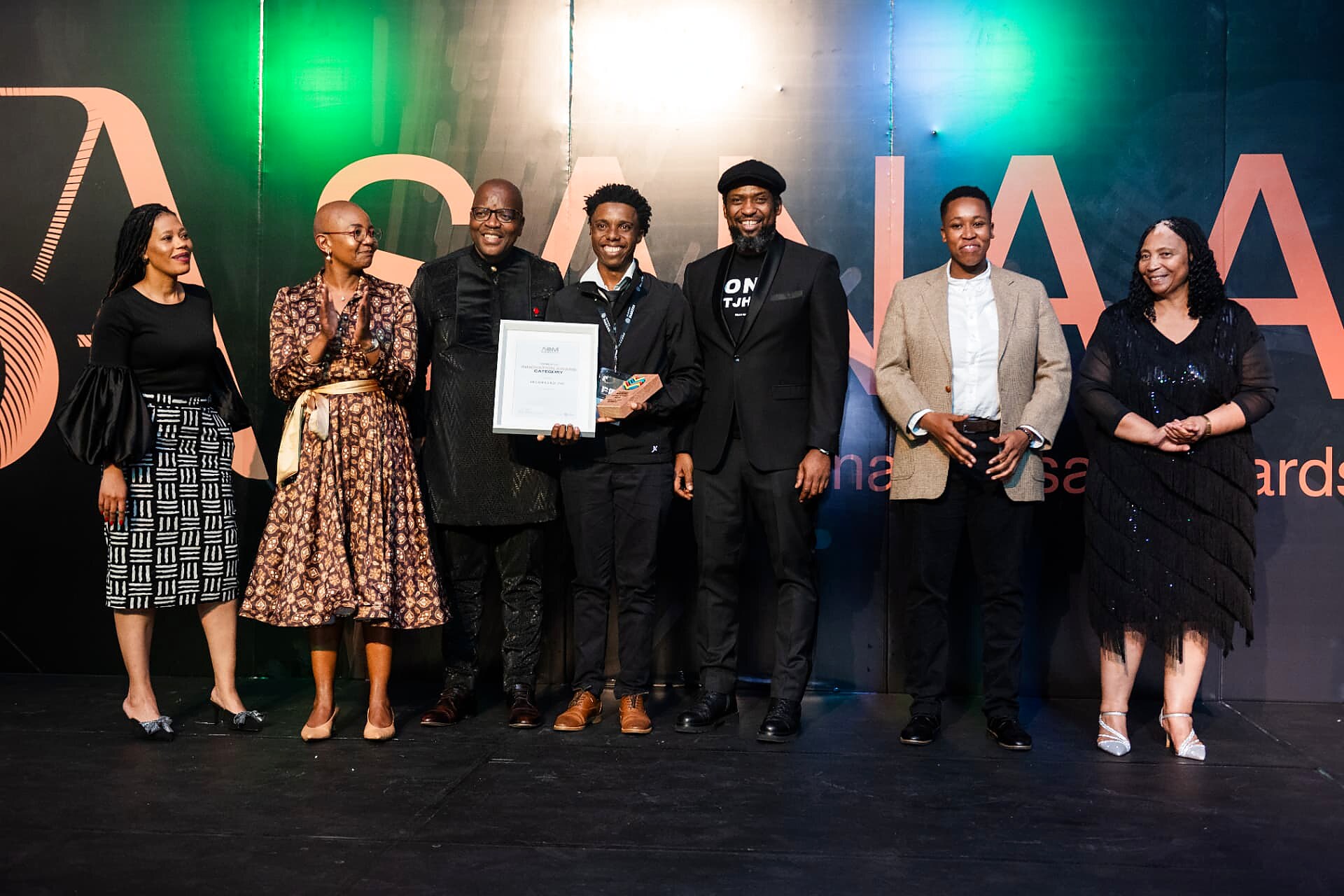 Innovation category winner receiving a framed certificate and trophy while the panel applauds