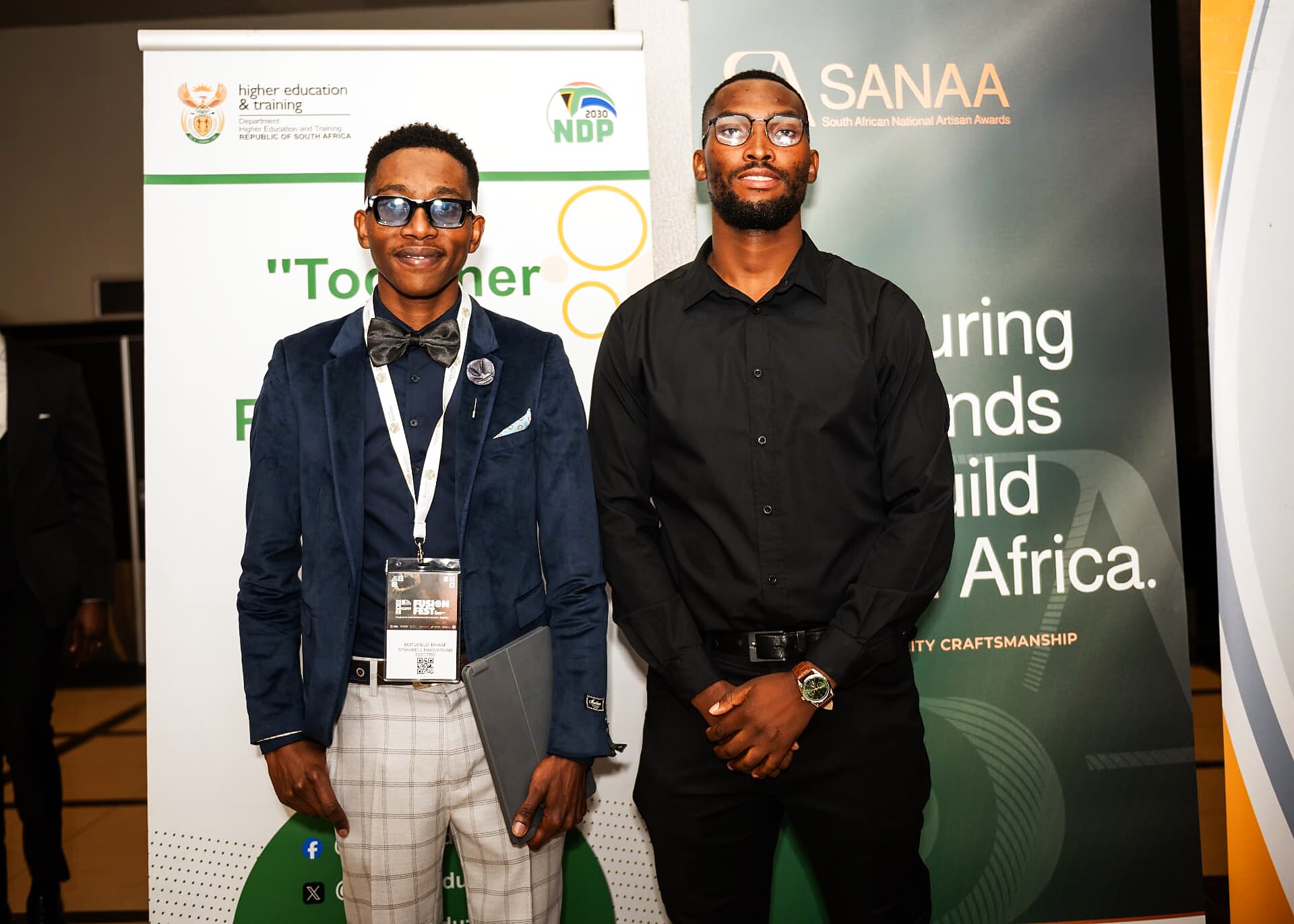 Two SANAA 2026 nominees posing beside the Department of Higher Education and SANAA banners