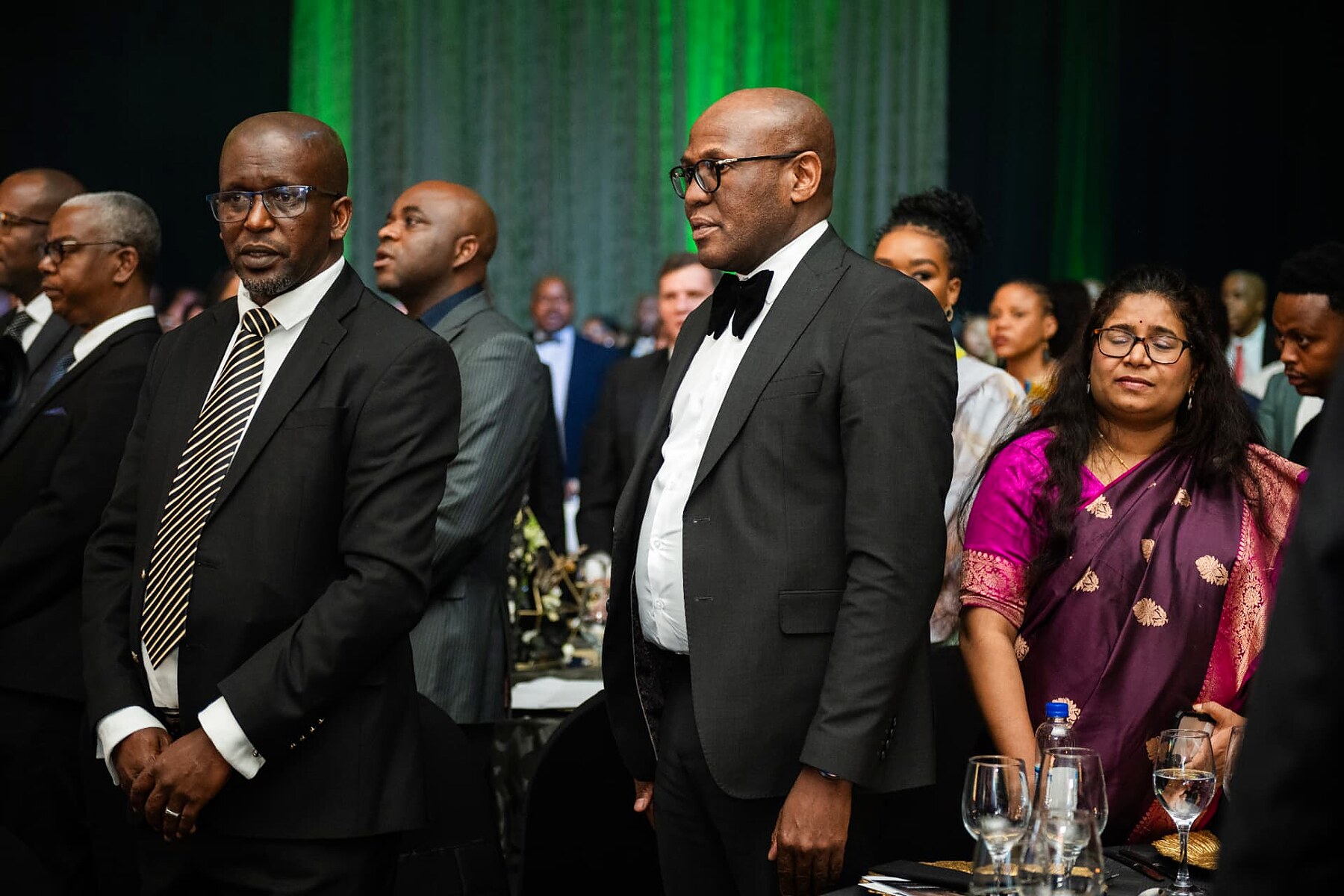 Senior delegates standing for the national anthem in the gala ballroom