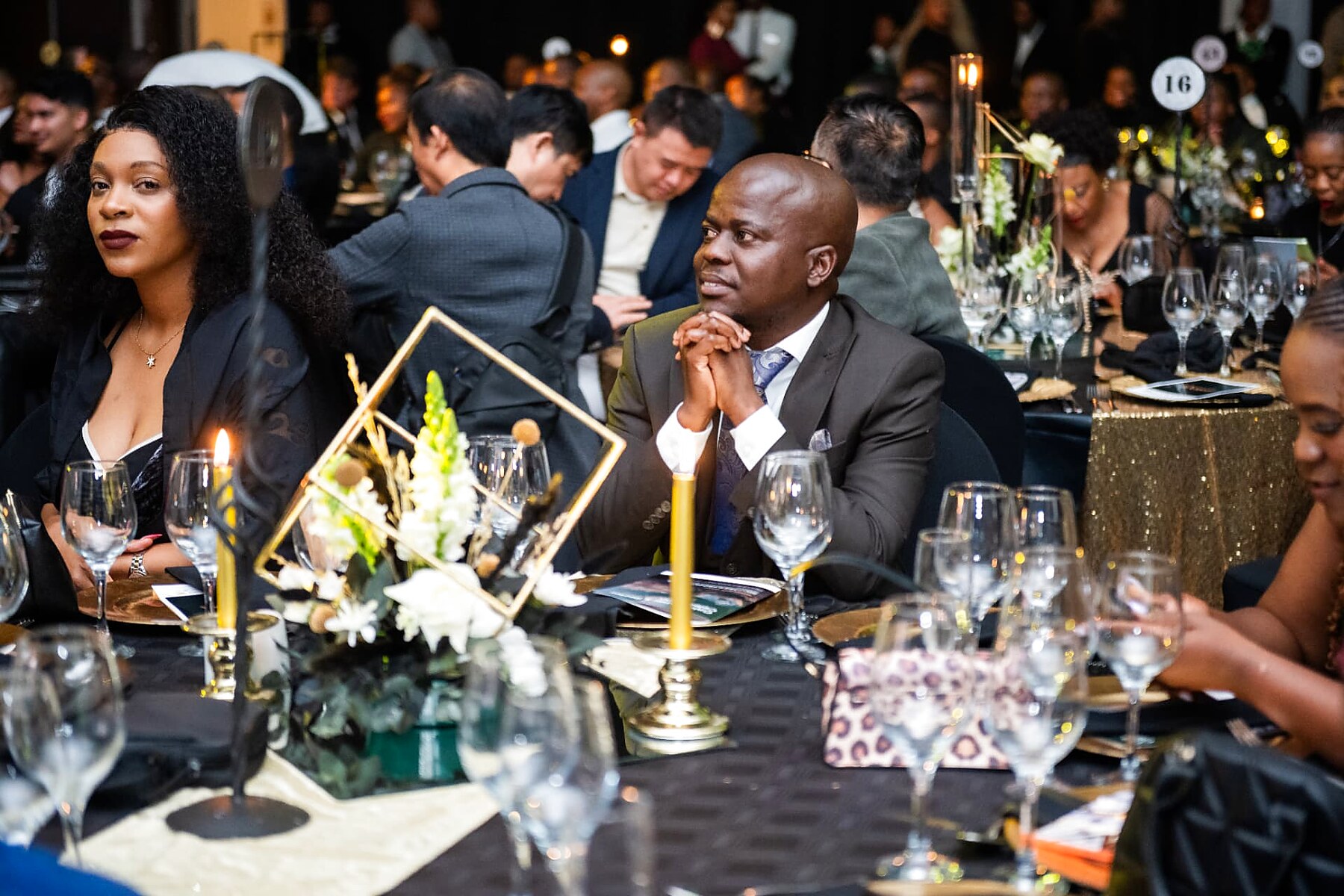 Guests seated at a candlelit table watching the awards ceremony
