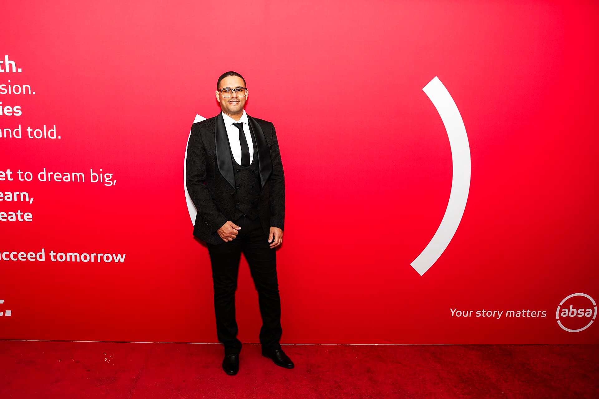 Nominee in a black tuxedo posing on the SANAA 2026 red carpet