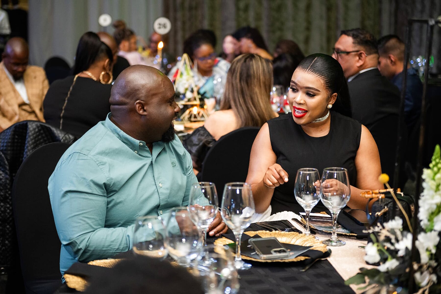 Two guests sharing a laugh over dinner at the gala