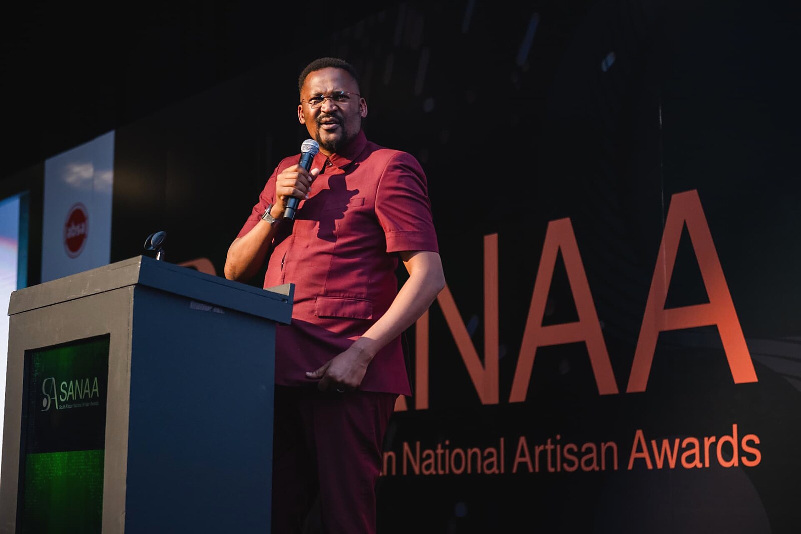 Guest speaker addressing the audience with a handheld microphone