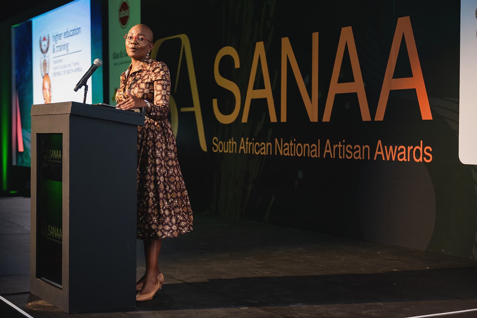 Programme director addressing guests from the SANAA podium