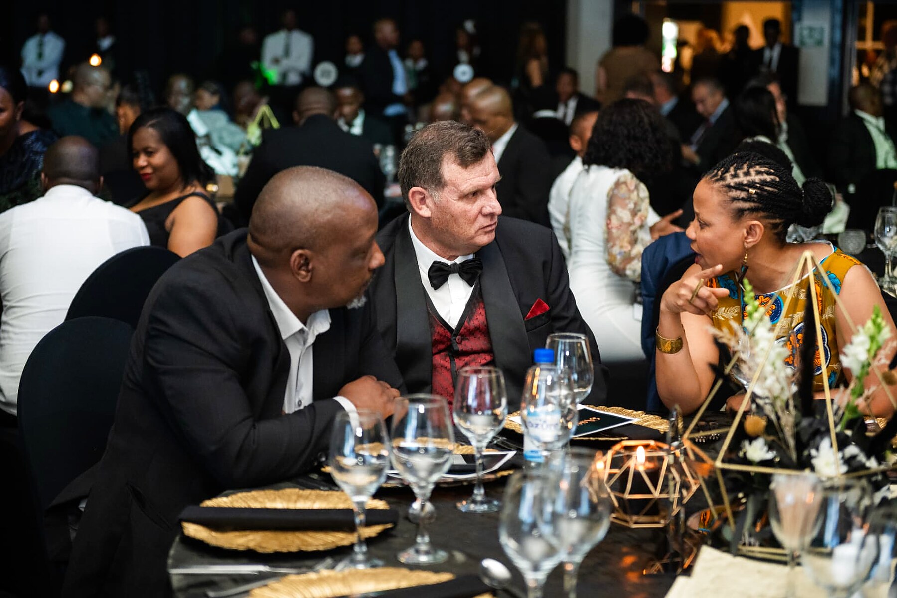 Guests in formal wear talking around a gala dinner table