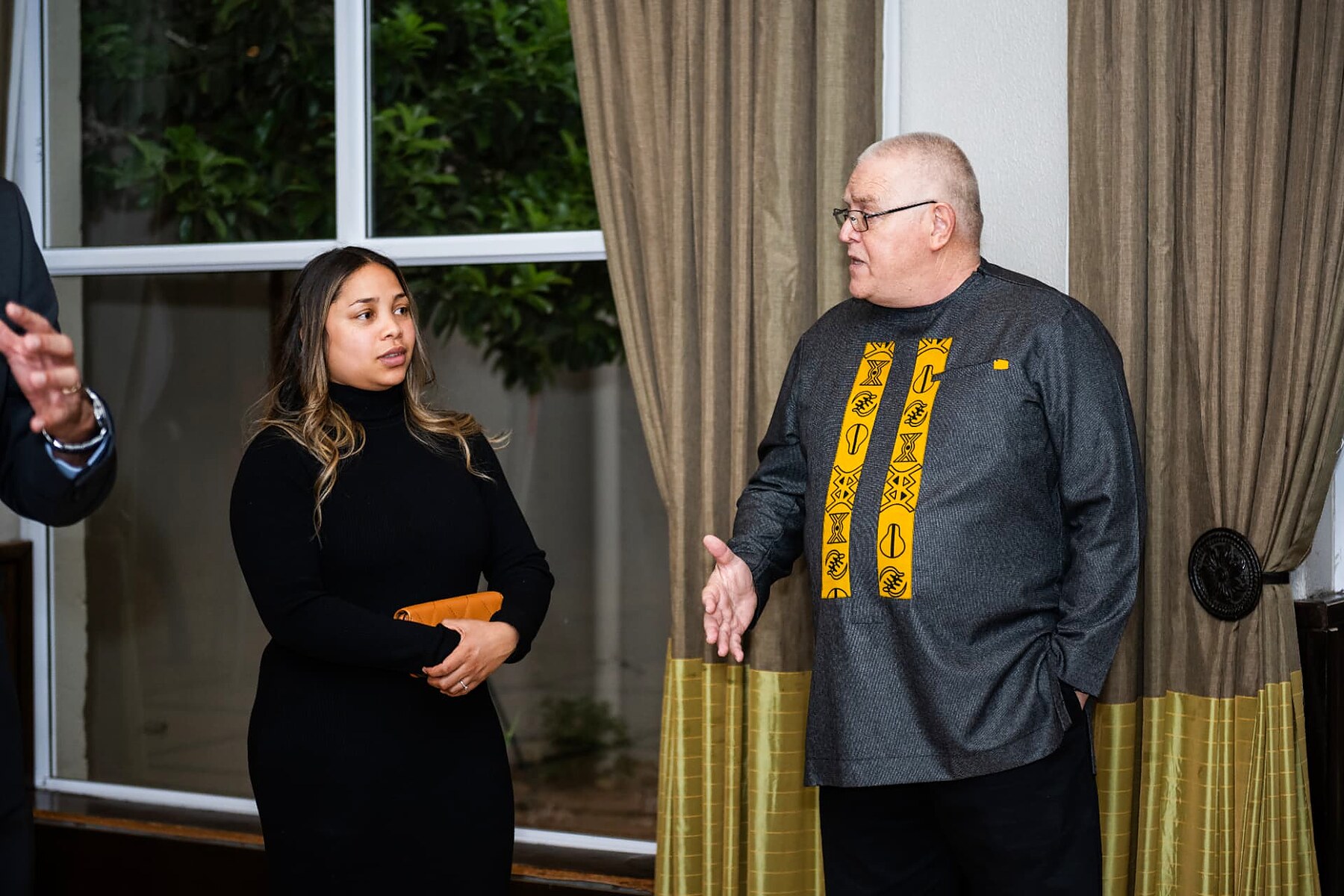 Guest in a patterned African shirt speaking with a colleague at the SANAA 2026 reception