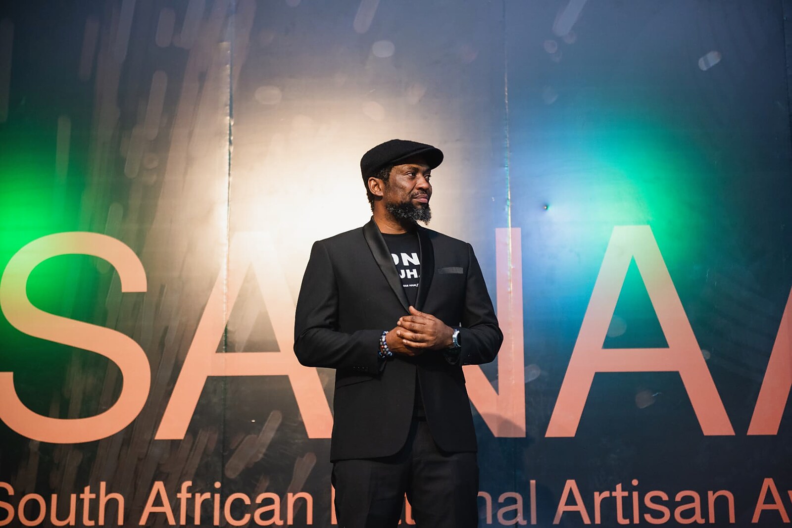 Host standing in front of the illuminated SANAA stage wall