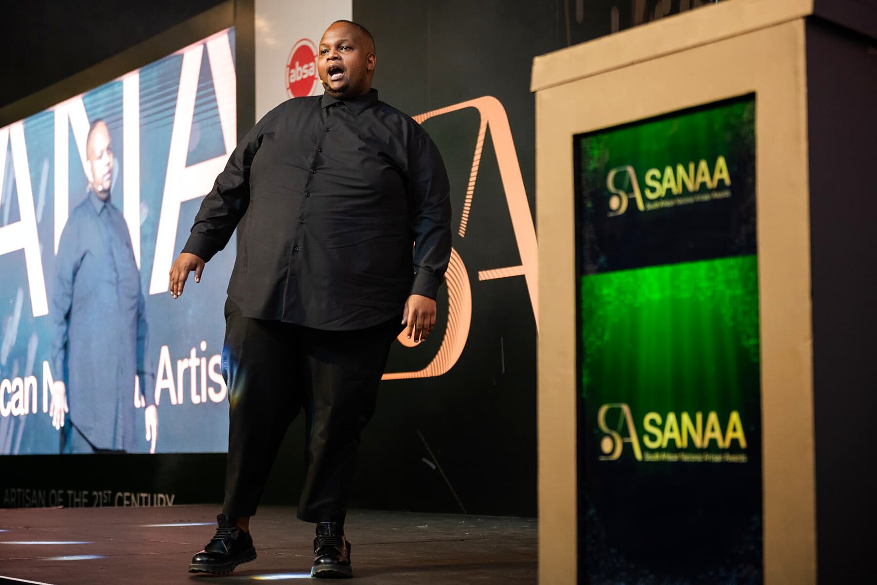 Performer on stage in front of the SANAA screens during the programme